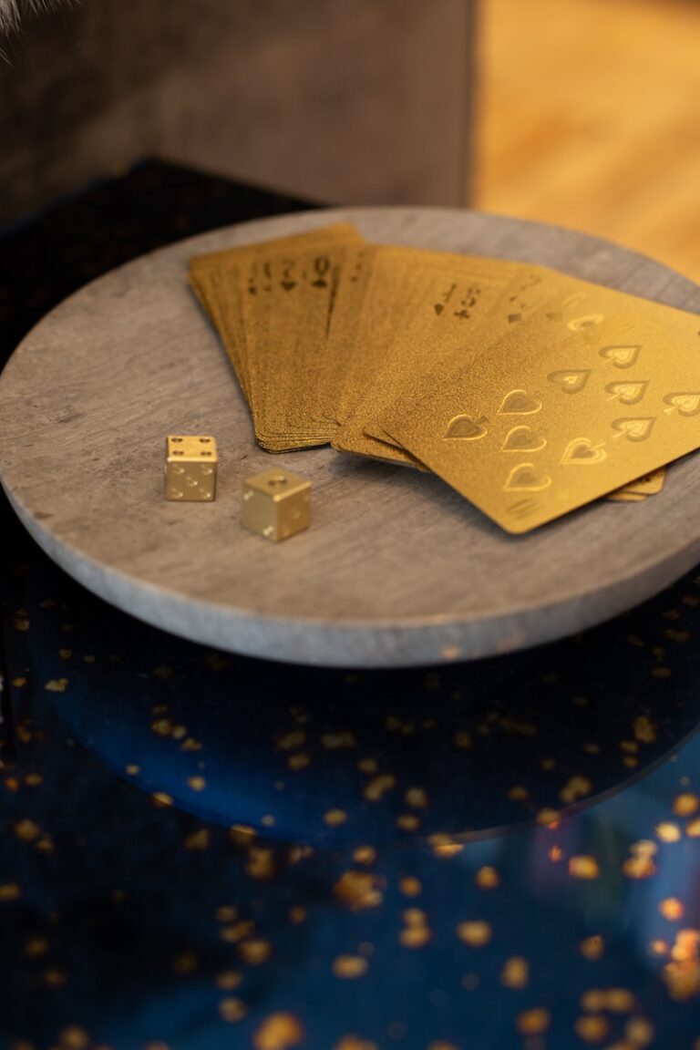 gold cards and two dices on round wooden platform-Exploring the Historical Significance of Gold