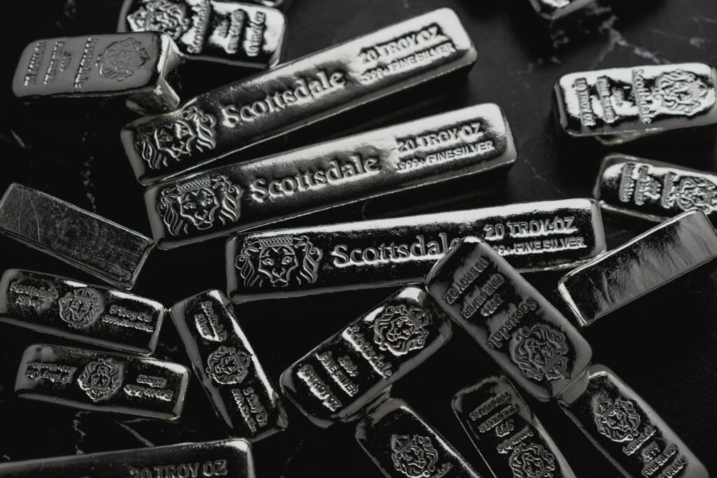 a pile of silver bars sitting on top of a table Gold and Silver Investments