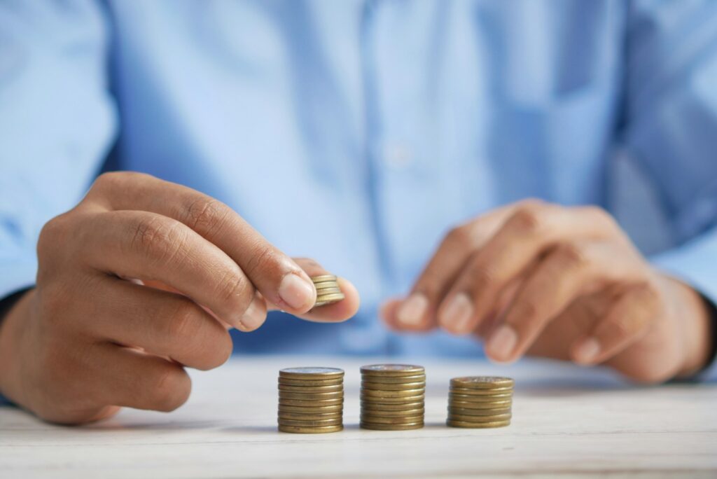 a person stacking coins on top of a table Silver Investments